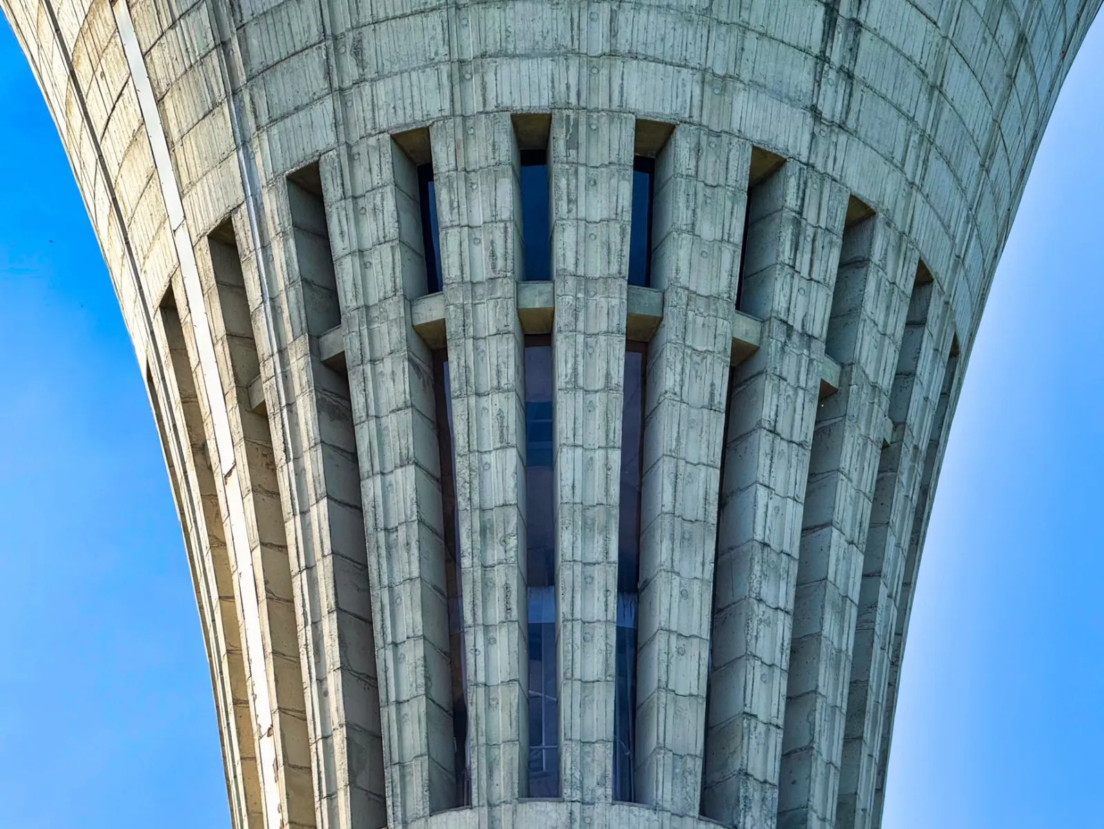 Detailed view of modern concrete architecture against a blue sky.